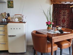 uma cozinha com uma pequena mesa e um frigorífico em Vintage Holiday Home in Kamperland em Kamperland