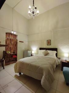 Un dormitorio con una cama grande y una lámpara de araña. en Casona de Sillar, en Arequipa