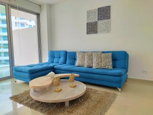 uma sala de estar com um sofá azul e uma mesa em Morros Epic em Cartagena das Índias