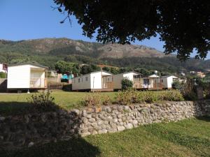a row of houses with mountains in the background at Camping 1ª O Muiño - Bungalow Park in Oia