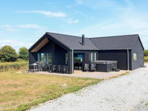 una casa nera con una griglia in un campo di Holiday home Bogense XXVIII a Bogense