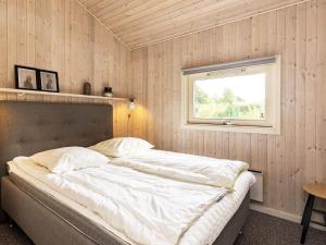 1 dormitorio con 1 cama grande y ventana en Holiday home Otterup XVIII en Otterup