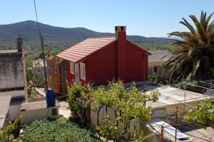 a red house with a palm tree and mountains in the background at Holiday house with a parking space Lukoran (Ugljan) - 6234 in Lukoran