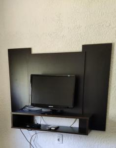 TV de pantalla plana en una estantería negra en Nuestro Sueño Ocean Park, en Sauce de Portezuelo