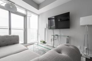 un soggiorno con un divano e una TV a parete di MMG Executive Suite - VIEWS FROM THE TOP a Toronto