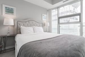 una camera da letto bianca con un letto grande e una finestra di MMG Executive Suite - VIEWS FROM THE TOP a Toronto