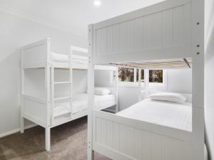 two bunk beds in a bedroom with white walls at 61 Myack Street in Berridale