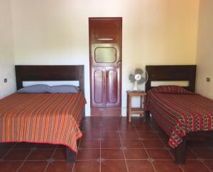 a bedroom with two beds and a fan at Lauris Hotel in Lanquín
