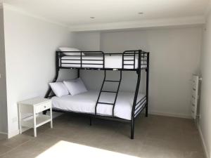 a bedroom with a bunk bed with white sheets and a table at Arlberg 204 Ski-In Ski-Out Studio Apartment in Mount Buller