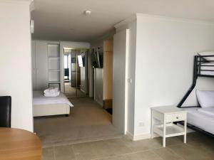 een kamer met 2 bedden en een kamer met een tafel bij Arlberg 204 Ski-In Ski-Out Studio Apartment in Mount Buller