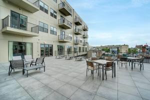 a patio with tables and chairs on a building at Huge 2 Bed 2 Bath Easy ride to NYC & Parking in Hackensack