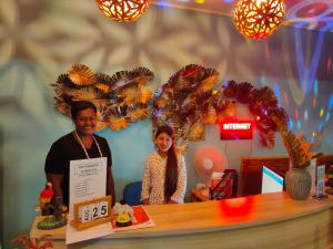 a man and a woman standing behind a counter at Nadi Fancy Hotel in Nadi