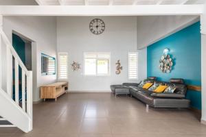 un salon avec un canapé et une horloge au mur dans l'établissement Villa de Standing avec piscine au Gosier, au Gosier