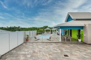une maison avec une terrasse et une clôture dans l'établissement Villa de Standing avec piscine au Gosier, au Gosier