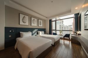 um quarto de hotel com duas camas e uma janela em Aaron Hotel em Nha Trang