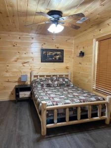 a bed in a log cabin with a ceiling fan at Paradise at the Smokies Cabin in Sevierville