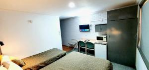 een kleine hotelkamer met een bed en een keuken bij Goldrush Motel Young CBD in Young
