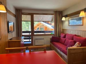 a living room with a red couch in front of a window at Appartement Plagne 1800, 2 pièces, 4 personnes - FR-1-351-40 in Plagne 1800