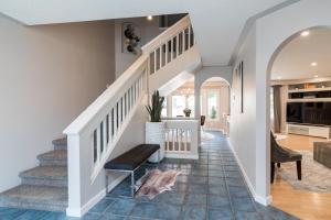 a staircase in a home with white walls and blue tile floors at Luxe Oasis Retreat: LG Grp, Pool, BBQ, 4BR, AC! in Winnipeg