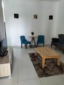 a living room with a wooden table and chairs at Noorsyah Homestay Stadium Utama in Kangar