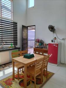 a kitchen with a wooden table and a red refrigerator at Noorsyah Homestay Stadium Utama in Kangar