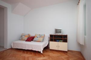 Cette petite chambre comprend un lit et une télévision sur une table. dans l'établissement Apartments with a parking space Tkon, Pasman - 6216, à Tkon