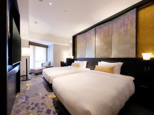 um quarto de hotel com duas camas e uma televisão em THE HOTEL SANRAKU KANAZAWA 21th December 2022 OPEN em Kanazawa
