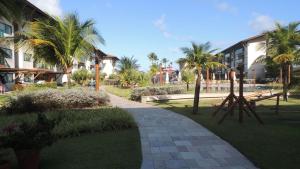 a walkway in a park with palm trees and buildings at La Fleur Polinésia Muro Alto in Porto De Galinhas