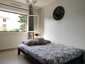a bedroom with a bed and a clock on the wall at 36 Dajot Studio Apartment - 25 in Melun