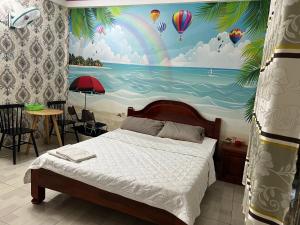 a bedroom with a painting of a beach and hot air balloons at Nhà Nghỉ Hồng Trang - Thủ Dầu Một in Xóm Mới (1)
