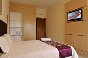 a bedroom with a bed and a tv on a wall at Geopark Hotel Kuah Langkawi in Kuah