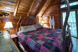 een slaapkamer met een bed in een blokhut bij Wild Columbine - Gatlinburg Area Hottub Romantic Cabin in Sevierville