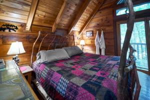 a bedroom with a bed in a log cabin at Wild Columbine - Gatlinburg Area Hottub Romantic Cabin in Sevierville