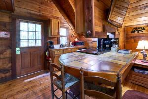 een keuken met een grote houten tafel in een huisje bij Wild Columbine - Gatlinburg Area Hottub Romantic Cabin in Sevierville