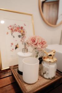 un bancone del bagno con lavandino, fiori e specchio di Mystay Hostel Nan a Nan