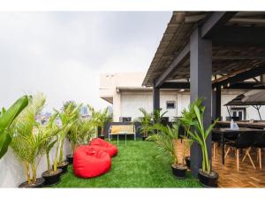 eine Terrasse mit roten Stühlen und Topfpflanzen in der Unterkunft Cove T63 in Jakarta