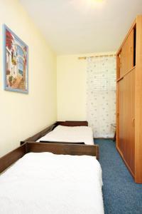 a room with two beds and a closet at Apartments by the sea Veli Iz, Iz - 6255 in Veli Iž