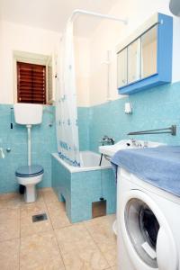 bagno con servizi igienici, lavandino e lavatrice di Apartments by the sea Veli Iz, Iz - 6255 a Veli Iž