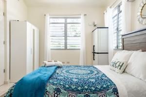 a bedroom with a bed with a blue blanket on it at Beautiful Ocean Front Villa in Aguada