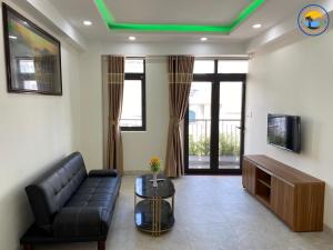 sala de estar con sofá y TV en Coastal House Nha Trang en Nha Trang