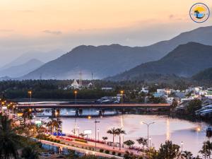 une ville de nuit avec des montagnes en arrière-plan dans l'établissement Coastal House Nha Trang, à Nha Trang