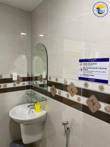 La salle de bains est pourvue d'un lavabo et d'un miroir. dans l'établissement Coastal House Nha Trang, à Nha Trang