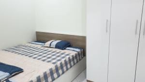 Dormitorio pequeño con cama con almohadas azules en Era Apartment Xuân Thuỷ, en Hanói