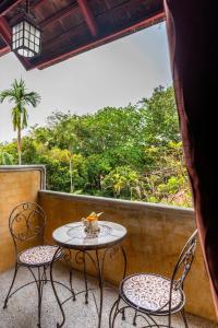 d'une table et de deux chaises sur un balcon avec vue. dans l'établissement Yaang Come Village Hotel - SHA Extra Plus, à Chiang Mai