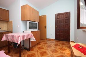 une petite cuisine avec une table et une télévision dans l'établissement Apartments with a parking space Sukosan, Zadar - 6332, à Sukošan