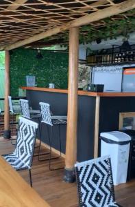 a bar with chairs and a table and a pole at Hostal Ana in Santa Marta