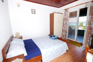 sypialnia z dwoma łóżkami i oknem w obiekcie Apartments by the sea Brgulje, Molat - 6250 w mieście Brgulje