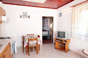 eine Küche mit einem Tisch und einem TV in der Küche in der Unterkunft Apartments by the sea Brgulje, Molat - 6250 in Brgulje