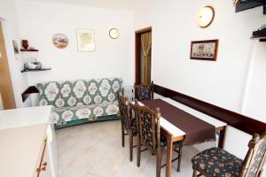 ein Esszimmer mit einem Tisch und einem Sofa in der Unterkunft Apartments by the sea Brgulje, Molat - 6243 in Molat