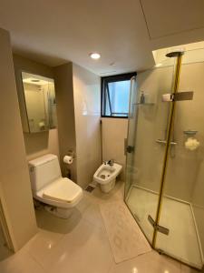 a bathroom with a toilet and a glass shower at KLCC Studio One Bedroom in Kuala Lumpur